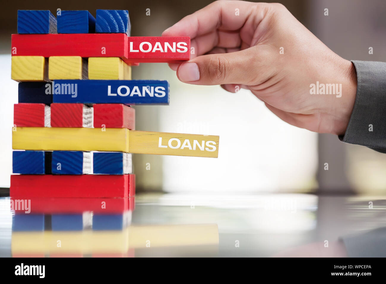 A business persons hand taking out many different types of loans, including long term and short term loans. Stock Photo