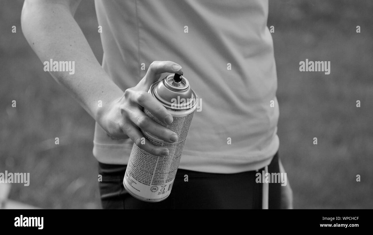 Holding a spray paint can ready to spray. Black and white picture of ...