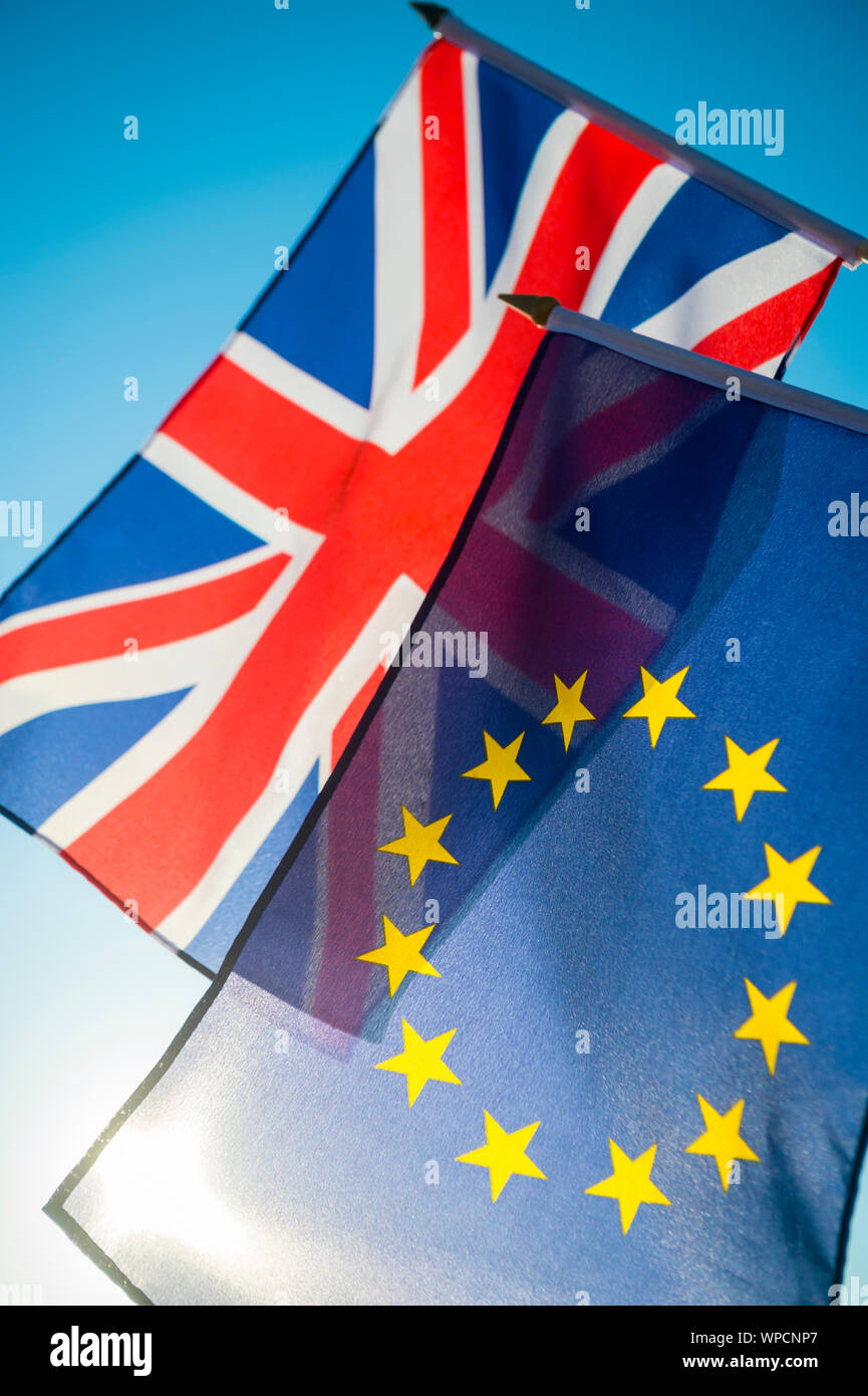 European Union and British Union Jack flag flying together in front of bright blue sky as the UK takes steps towards Brexit, leaving the EU Stock Photo