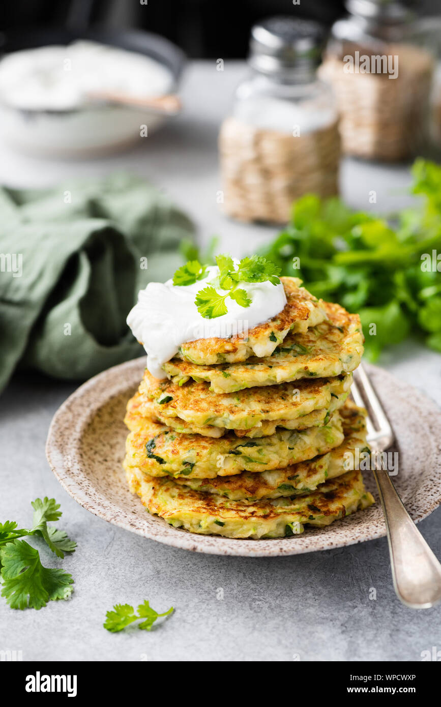 Zucchini quinoa fritters with sour cream. Vegetable pancakes ready for eating. Healthy