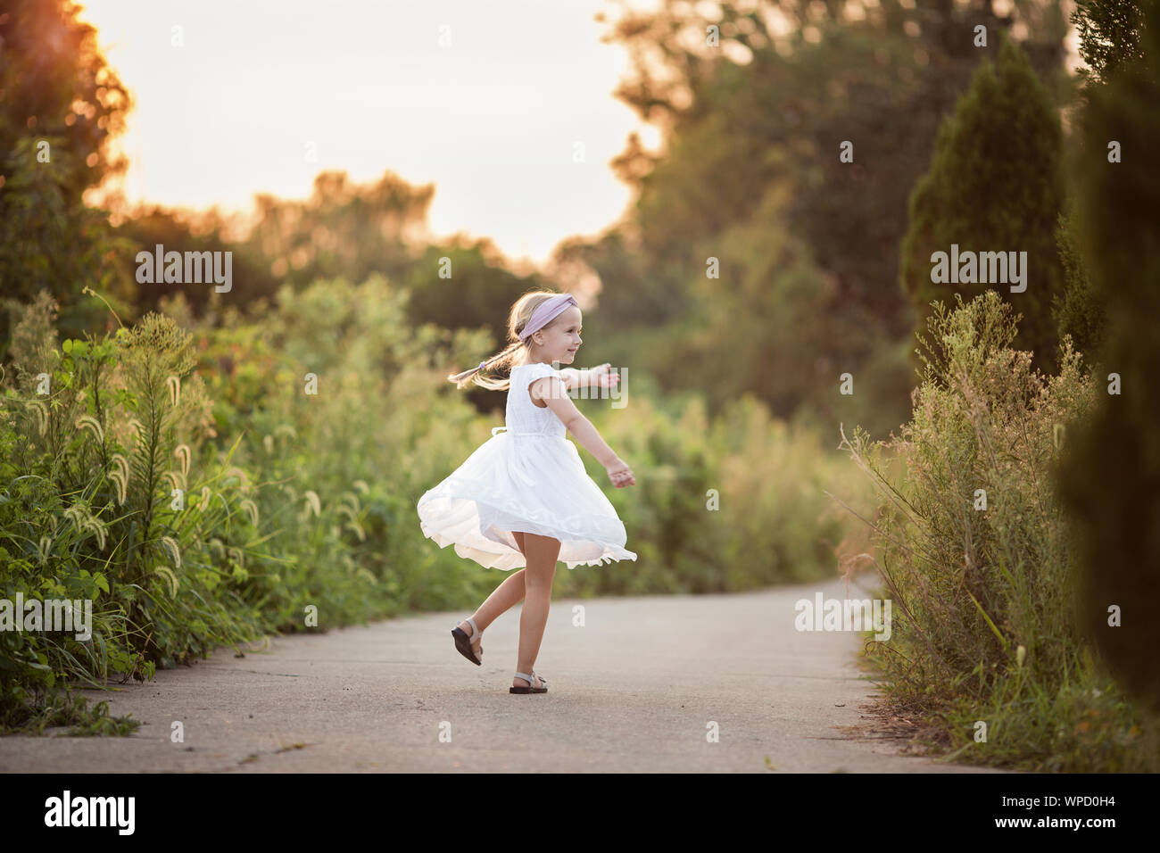 Portrait of adorable little girl with long blonde hair in the park ...