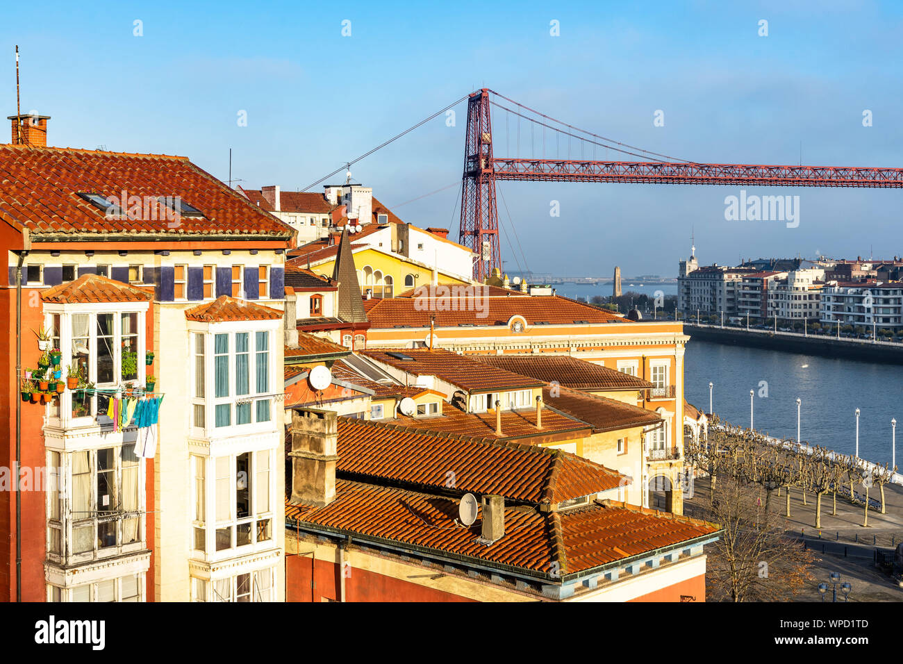 Iron tower of the Vizcaya Bridge emerging between the colorful buildings and roofs of Portugalete, Basque Country, Spain Stock Photo