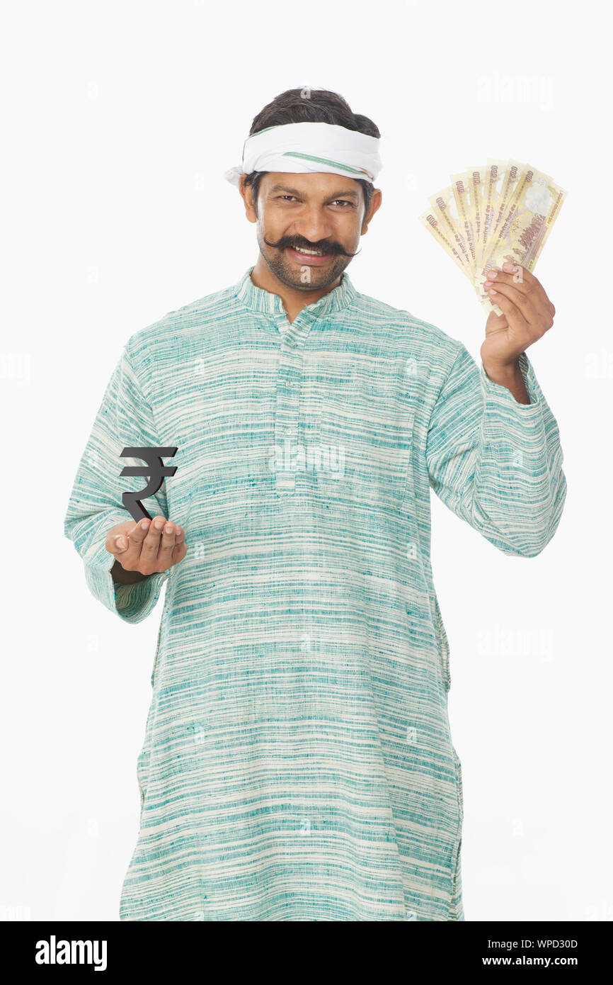 Rural man smiling and showing banknotes with rupee symbol Stock Photo