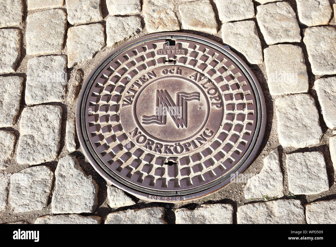 Norrkoping, Sweden - September 2, 2019: A manhole lid at the Drottninggatan strett with city of Norrkoping emblem. Stock Photo