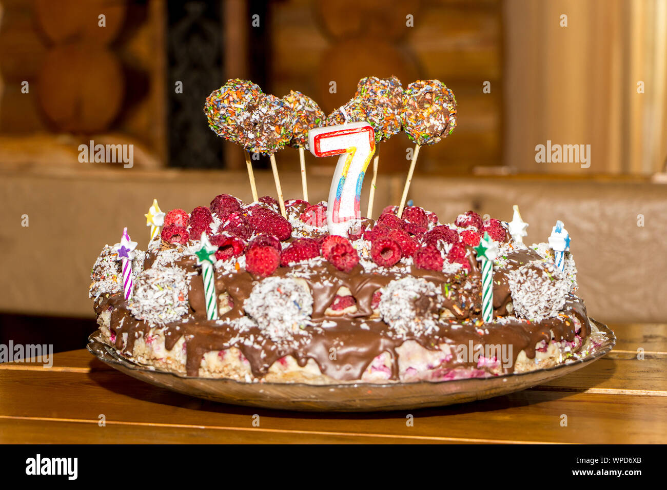 Celebrating the seventh birthday of child. Unbaked natural birthday cake with candles. Stock Photo