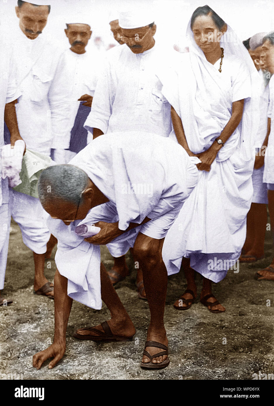 Mahatma Gandhi breaking salt law by picking up lump of natural salt, Dandi, India, April 6, 1930 Stock Photo