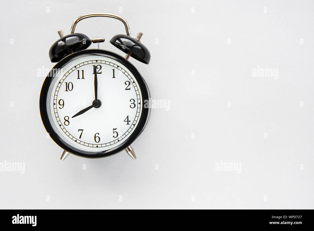 A black alarm clock isolated against white background Stock Photo - Alamy