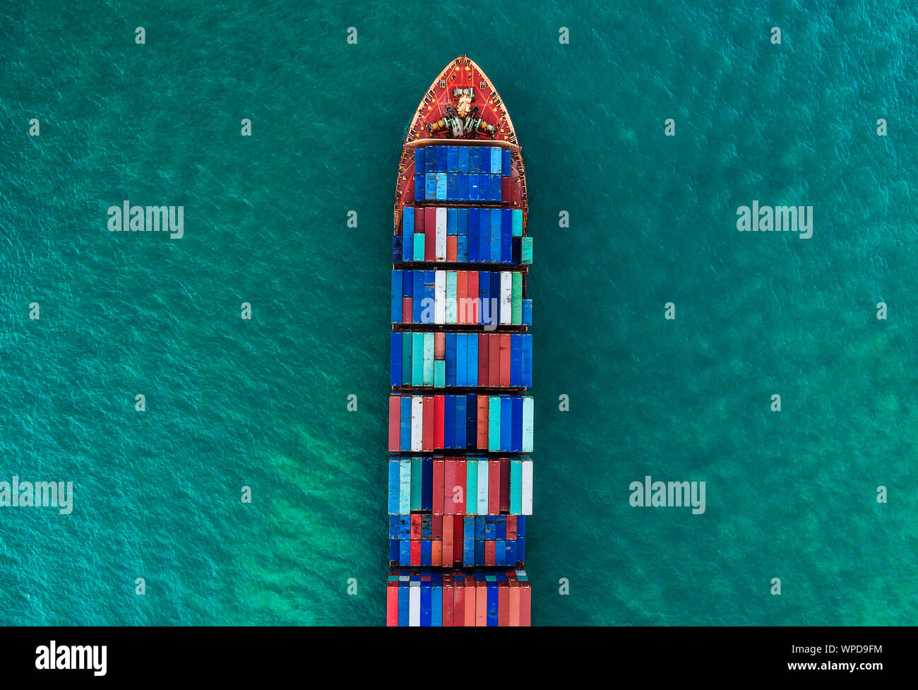 a cargo ship carrying multi-stack of containers in sea crossing international waters an aerial view, Singapore Stock Photo