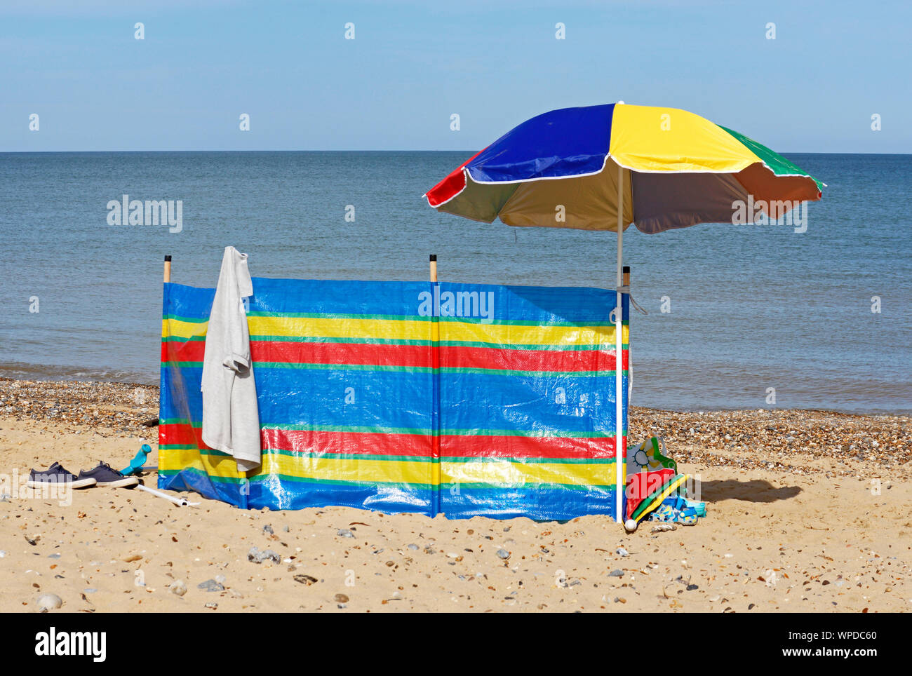 A windbreak and sunshade umbrella on the beach by the sea at Cart Gap ...