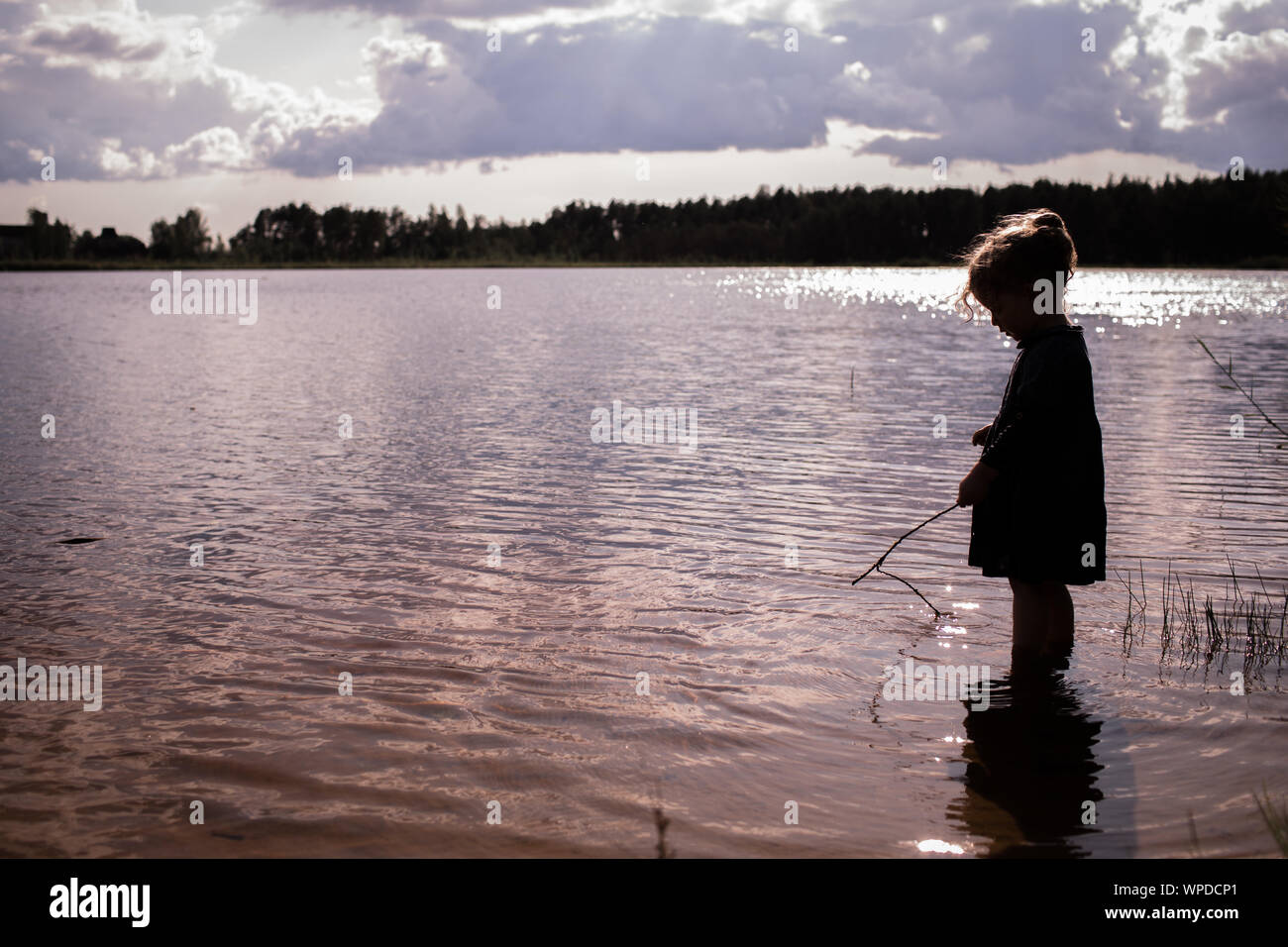 Little girl child, learning and exploring nature, outdoors in lake, free space for your text Stock Photo