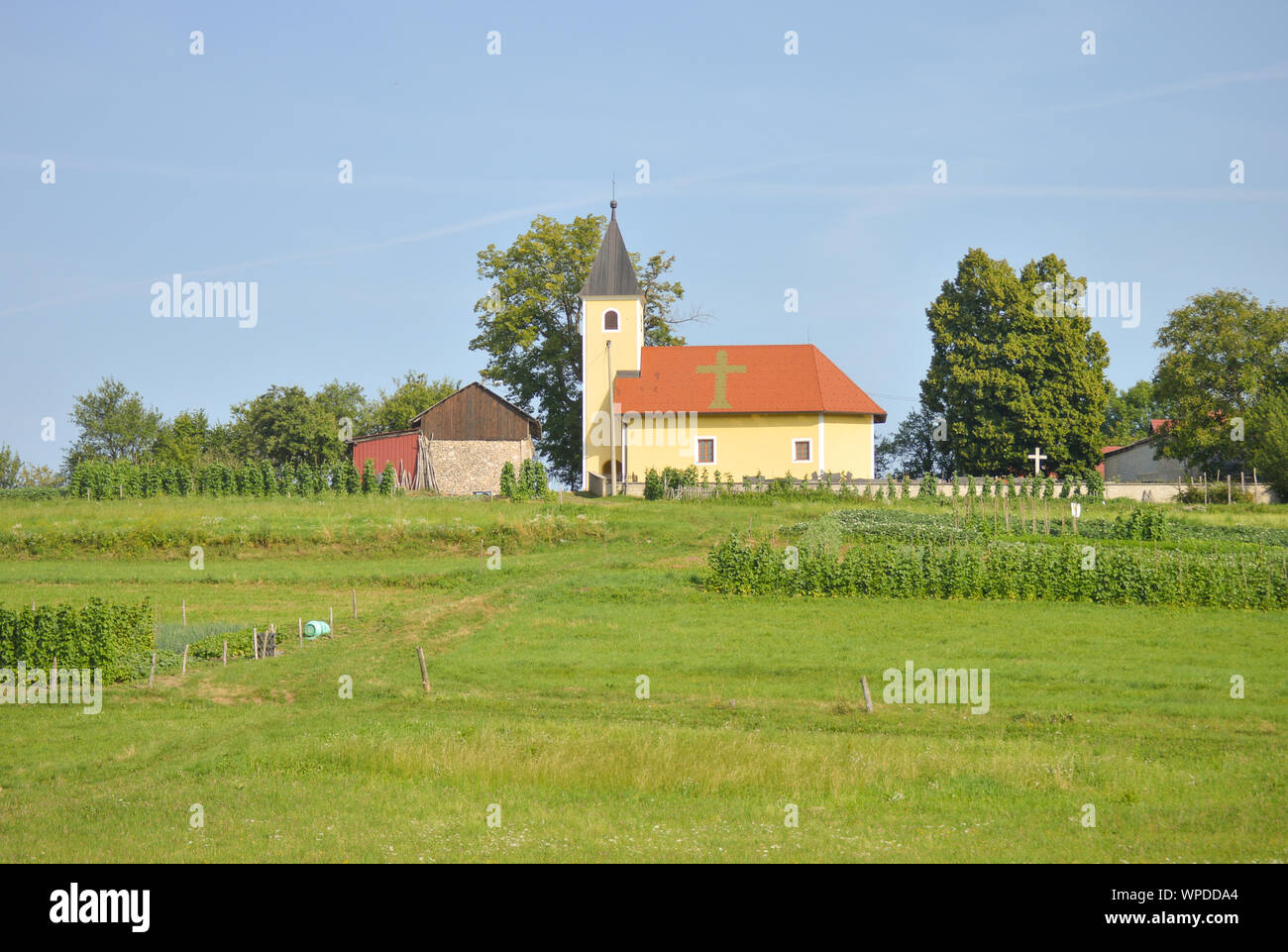 Village Dragonoš in Croatia, cultivated land, Church on top of hill Stock Photo