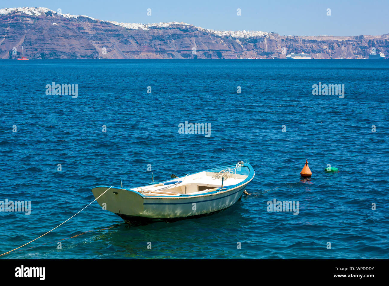 A little boat in the Santorini's bay in Greece. Stock Photo