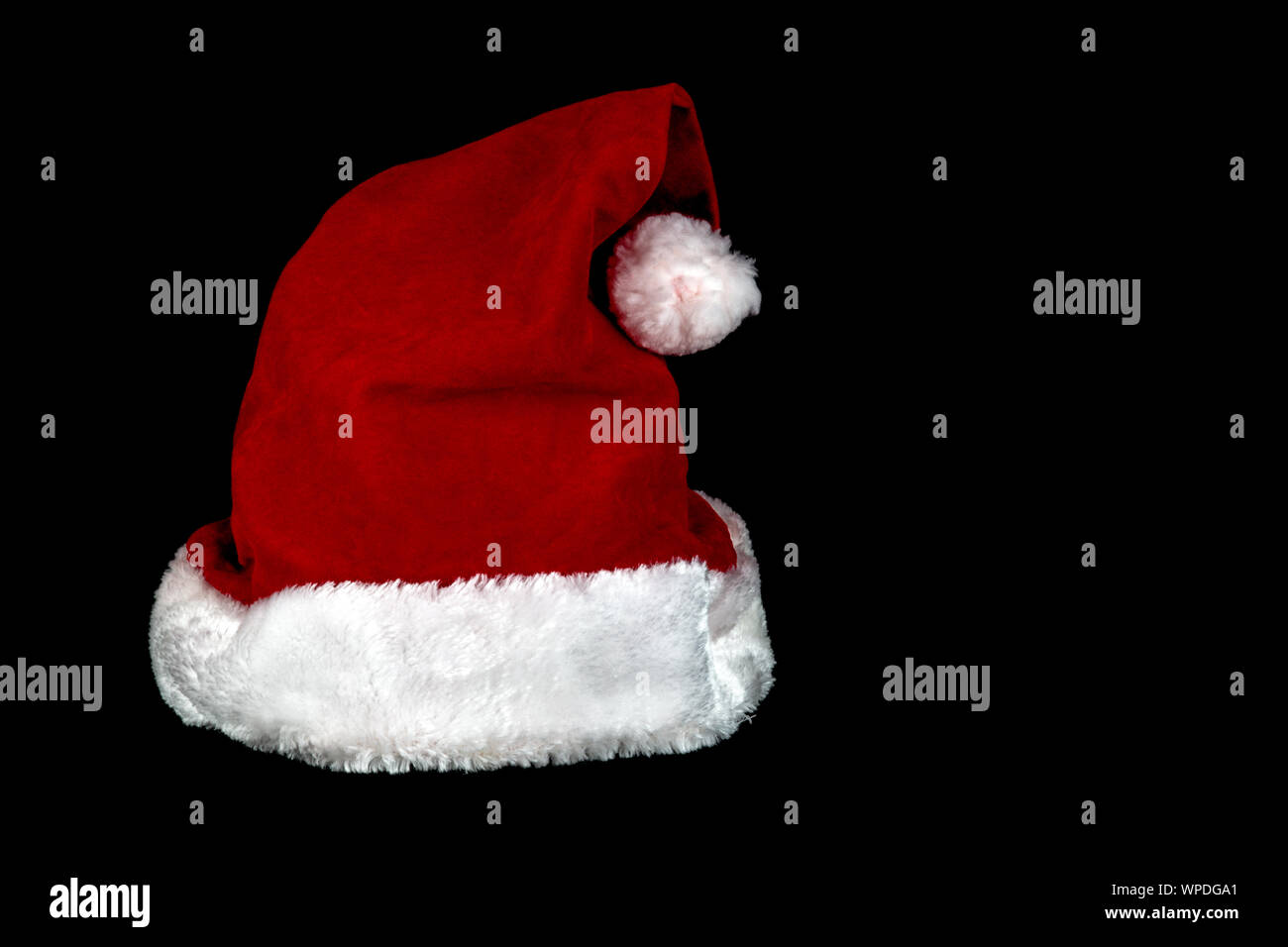 A Christmas santa hat isolated against a black background Stock Photo