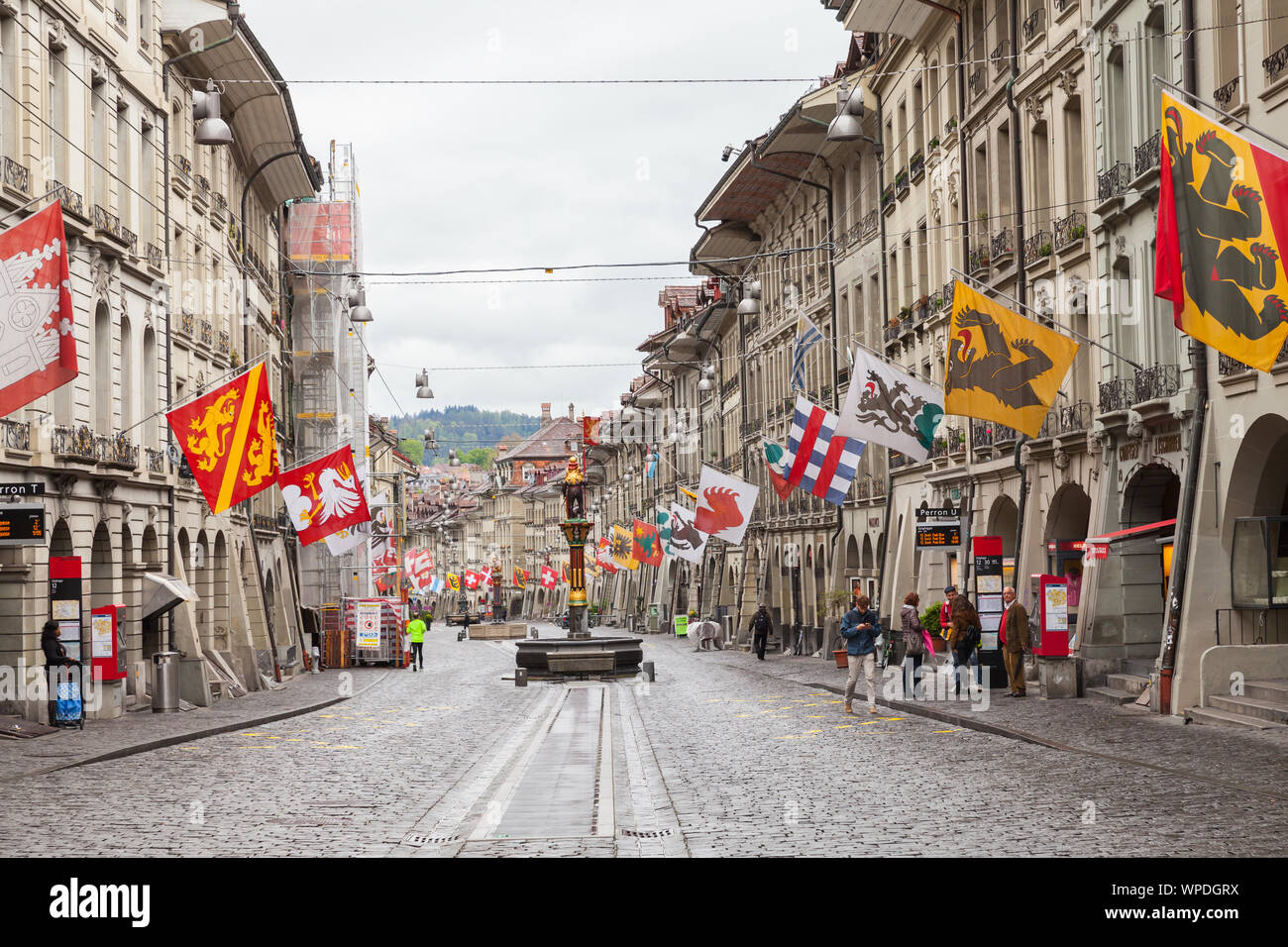 Bern, Switzerland - May 7, 2017: Street view of Grocers Alley. It is one of the principal streets in the Old City of Bern. People walk under colorful Stock Photo
