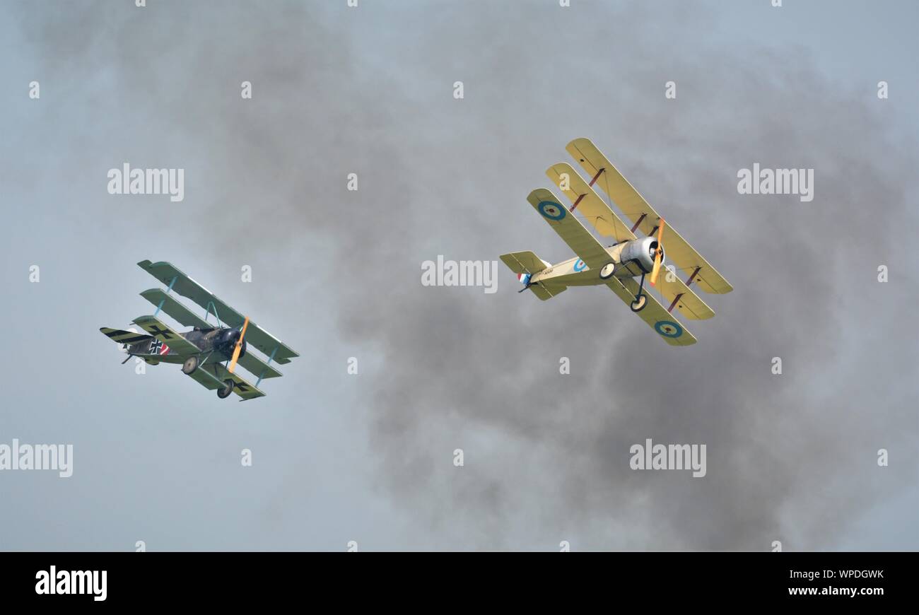 World war 1 aircraft in a dog fight, fokker tri plane and sopwith tri plane. In smokey  skies , reenactment  on early air combat. Stock Photo