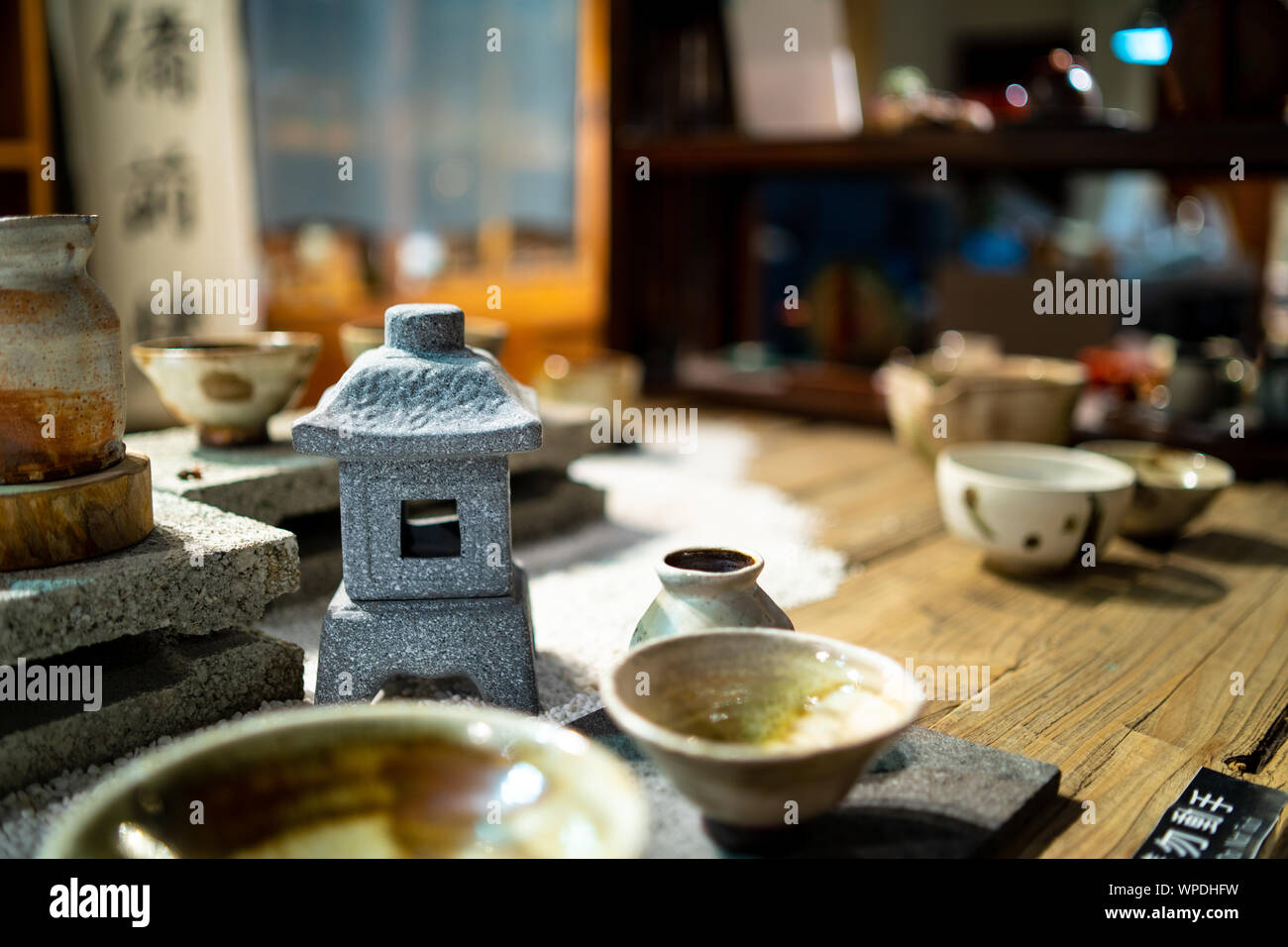 Taipei, Taiwan: Wooden table at traditional tea house in Jiufen, Taiwan. Laid with beautiful handmade, ceramic tea cups with blurry background Stock Photo