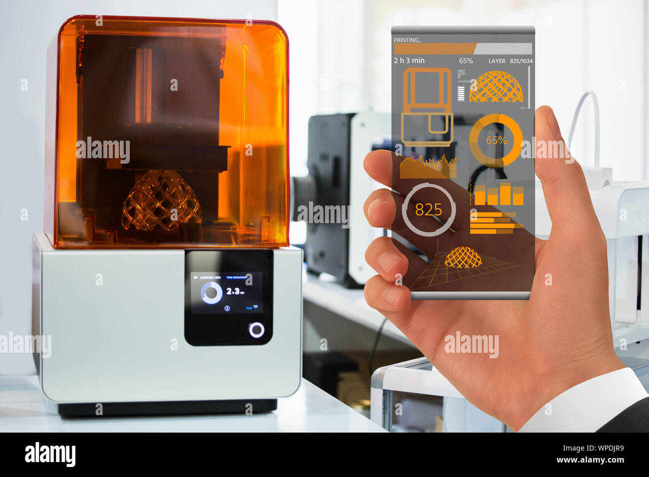 Hand with futuristic transparent smartphone. Application for control 3D printer in the laboratory. Stock Photo