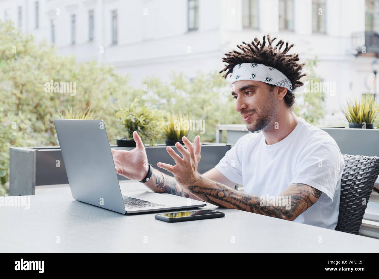 Young millennial business man recording vlog talking to web camera in coffee shop, successful male business trainer coach filming live video blog, mak Stock Photo