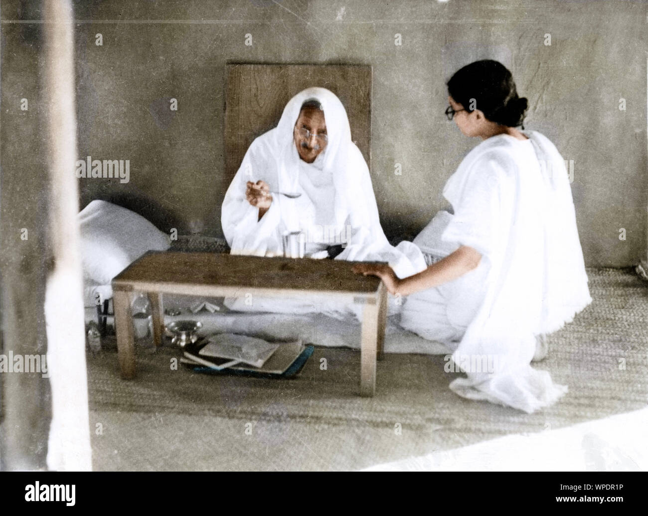 Mahatma Gandhi eating and talking with Abha Gandhi, India, Asia, 1946 Stock Photo