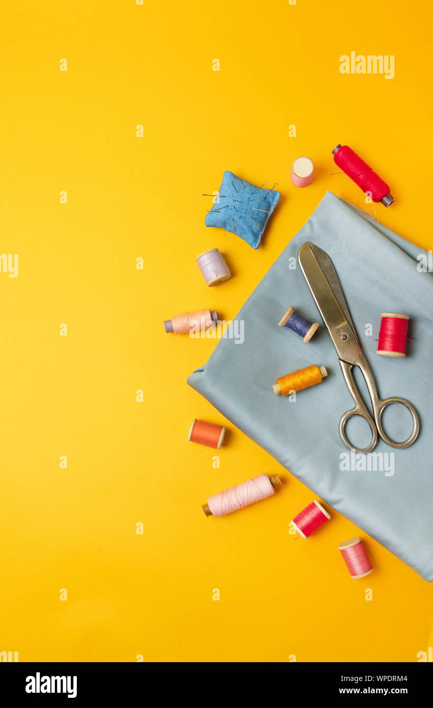 Sewing accessories on a colored yellow background top view. Stock Photo