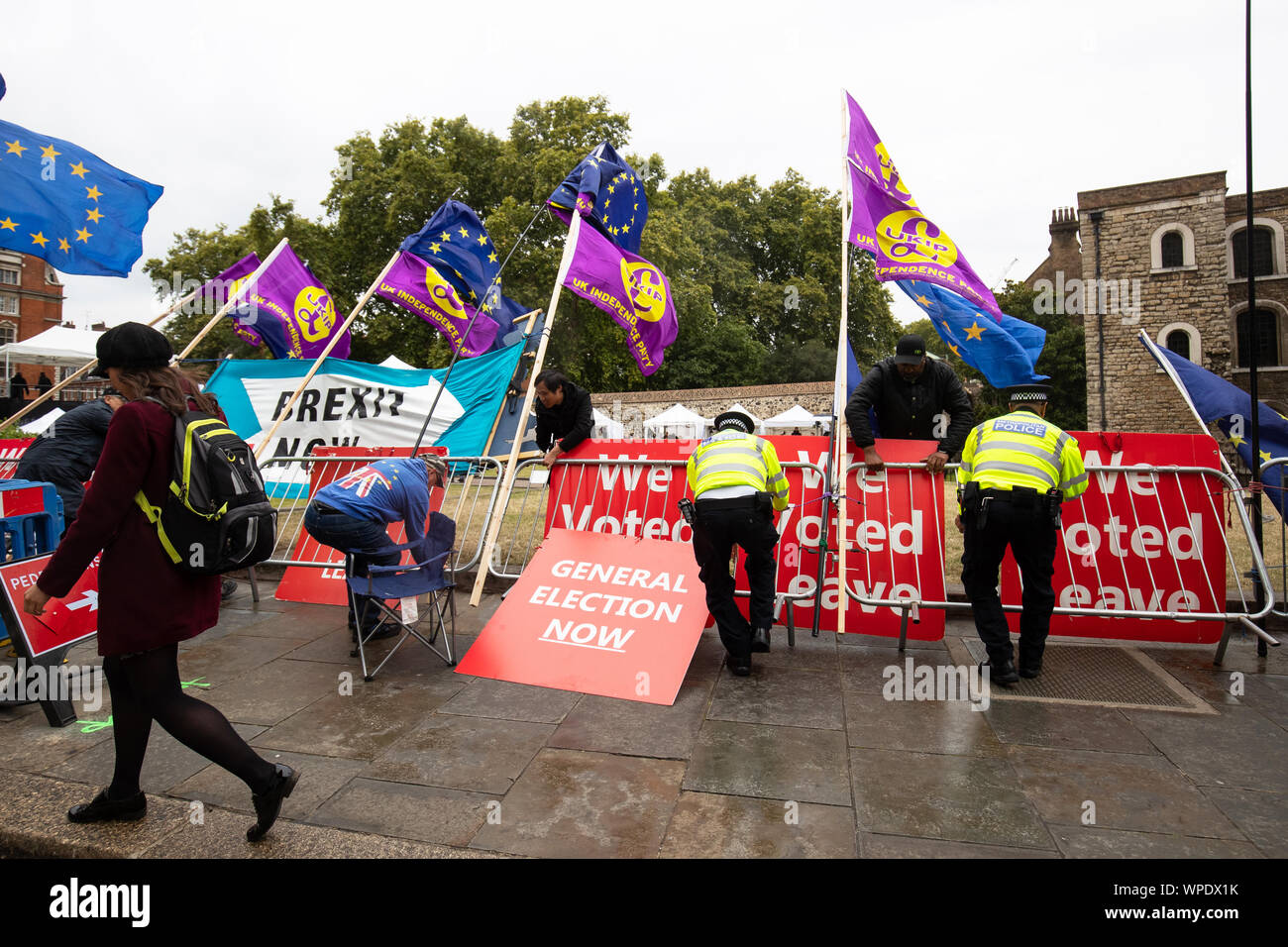A lull in the protests as fences holding up signs and flags for Remain and Leave topple over in the wind on College Green in Westminster, London. Stock Photo