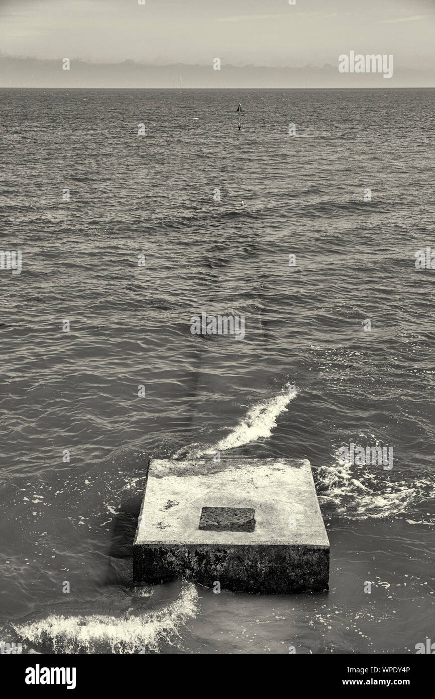 B&W, black&white, concrete outfall on the beach in Wales with wind farm ...