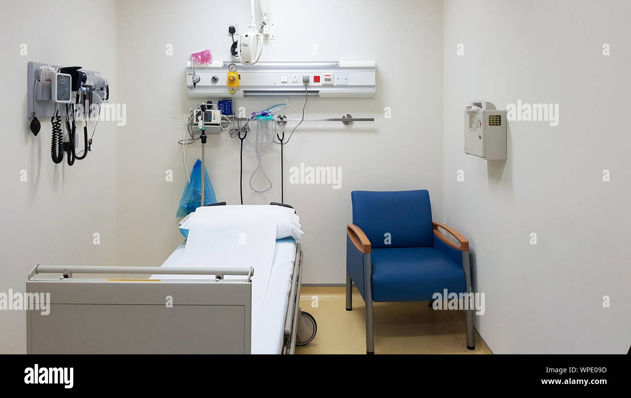 Empty hospital room with one bed, one chair and medical instruments on the wall. Health care concept. Medical room template Stock Photo