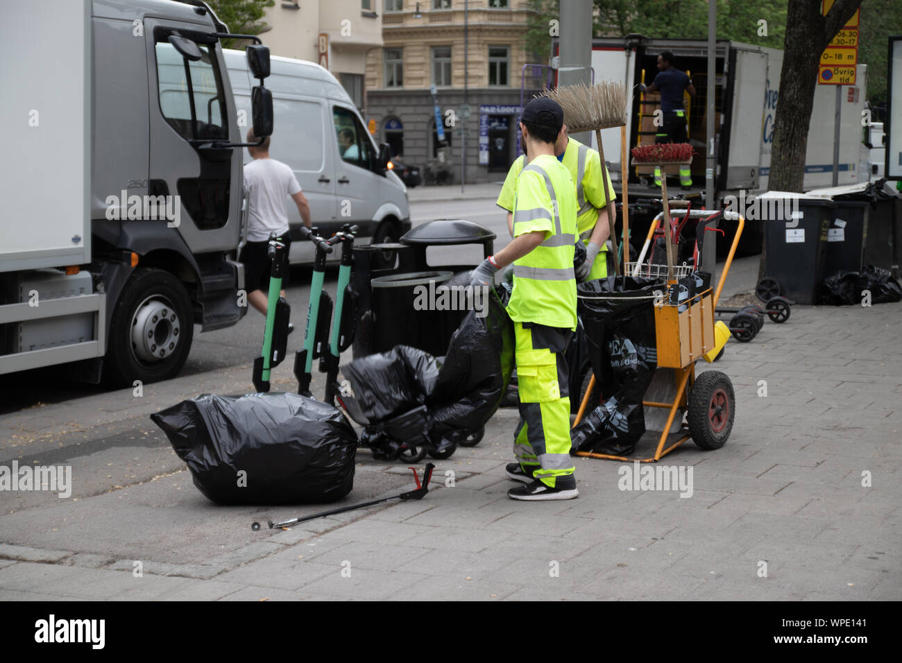 Stockholm, Sweden June 7 2019: Caring for ecology concept. Garbage sorting. Garbage collection worker putting bin into waste truck. For removal Stock Photo