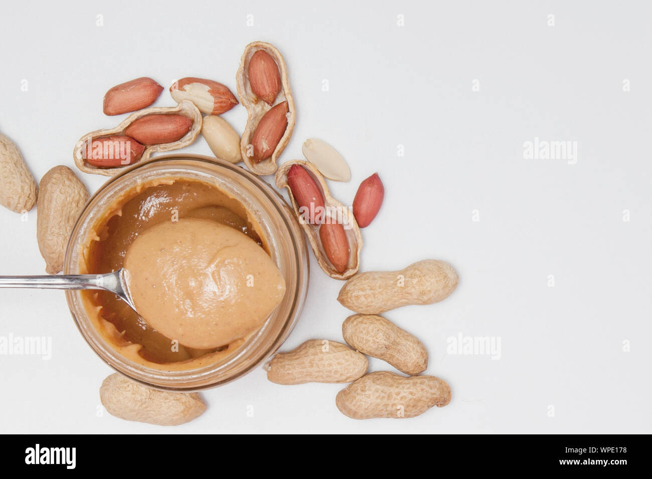 https://c8.alamy.com/comp/WPE178/creamy-peanut-butter-in-glass-jar-peanut-and-spoon-isolated-on-white-background-a-traditional-product-of-american-cuisine-WPE178.jpg