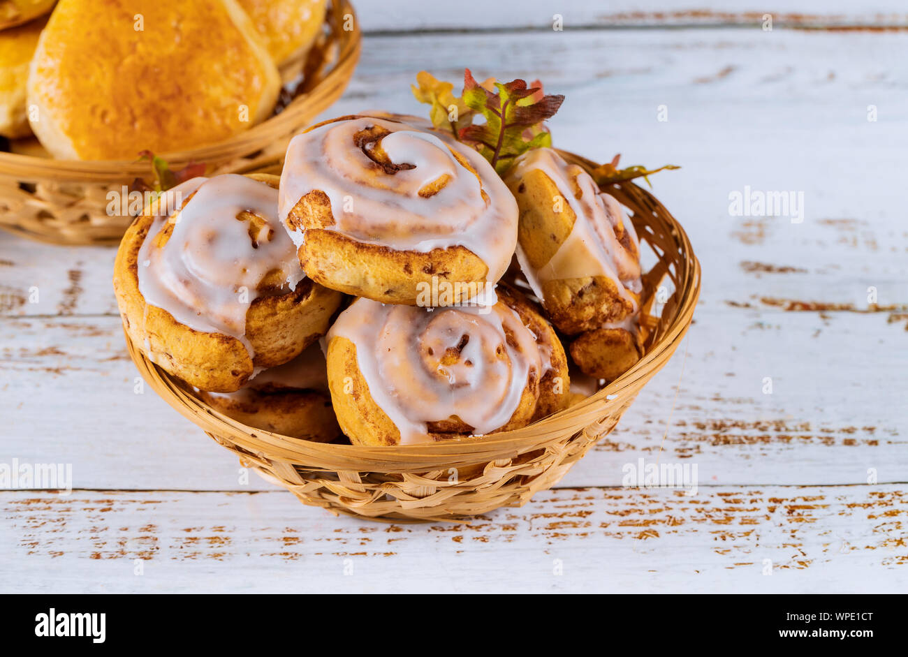 Cinnamon rolls with glaze on the top in wooden plate. Stock Photo