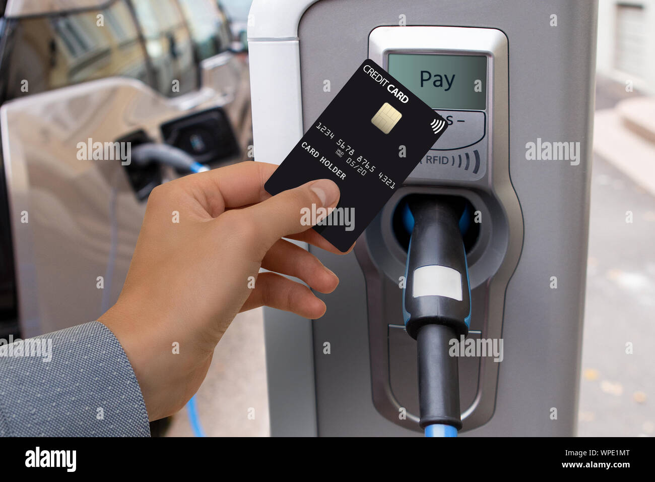 A man pays for charging an electric car. Stock Photo