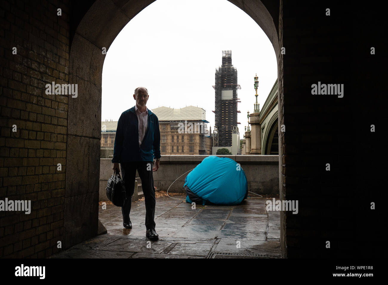 A man walks by a tent of a homeless person near the Houses of Parliament, Westminster, London. PA Photo. Picture date: Monday September 9, 2019. Brexit continues and life goes on in Westminster. See PA story POLITICS Brexit. Photo credit should read: Aaron Chown/PA Wire Stock Photo