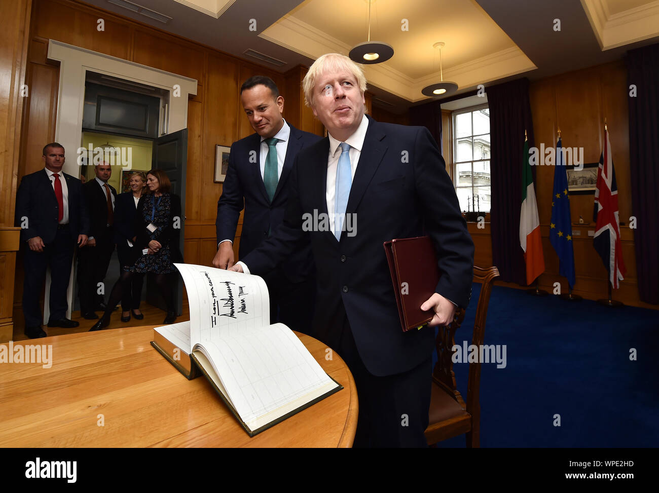 Prime Minister Boris Johnson opens a guestbook at the page signed by U.S President Donald Trump and U.S First Lady Melania Trump during his meeting with Irish Taoiseach Leo Varadkar at Government Buildingsin Dublin. Stock Photo