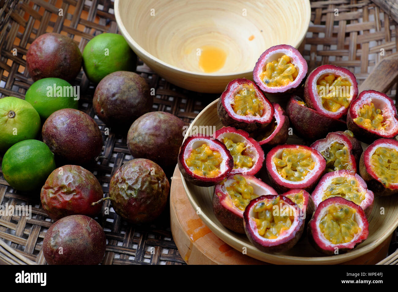 Basket passion fruits and passiflora edulis cut in half, kind of seedy fruit or  with soft pulp and seeds inside hard rind Stock Photo