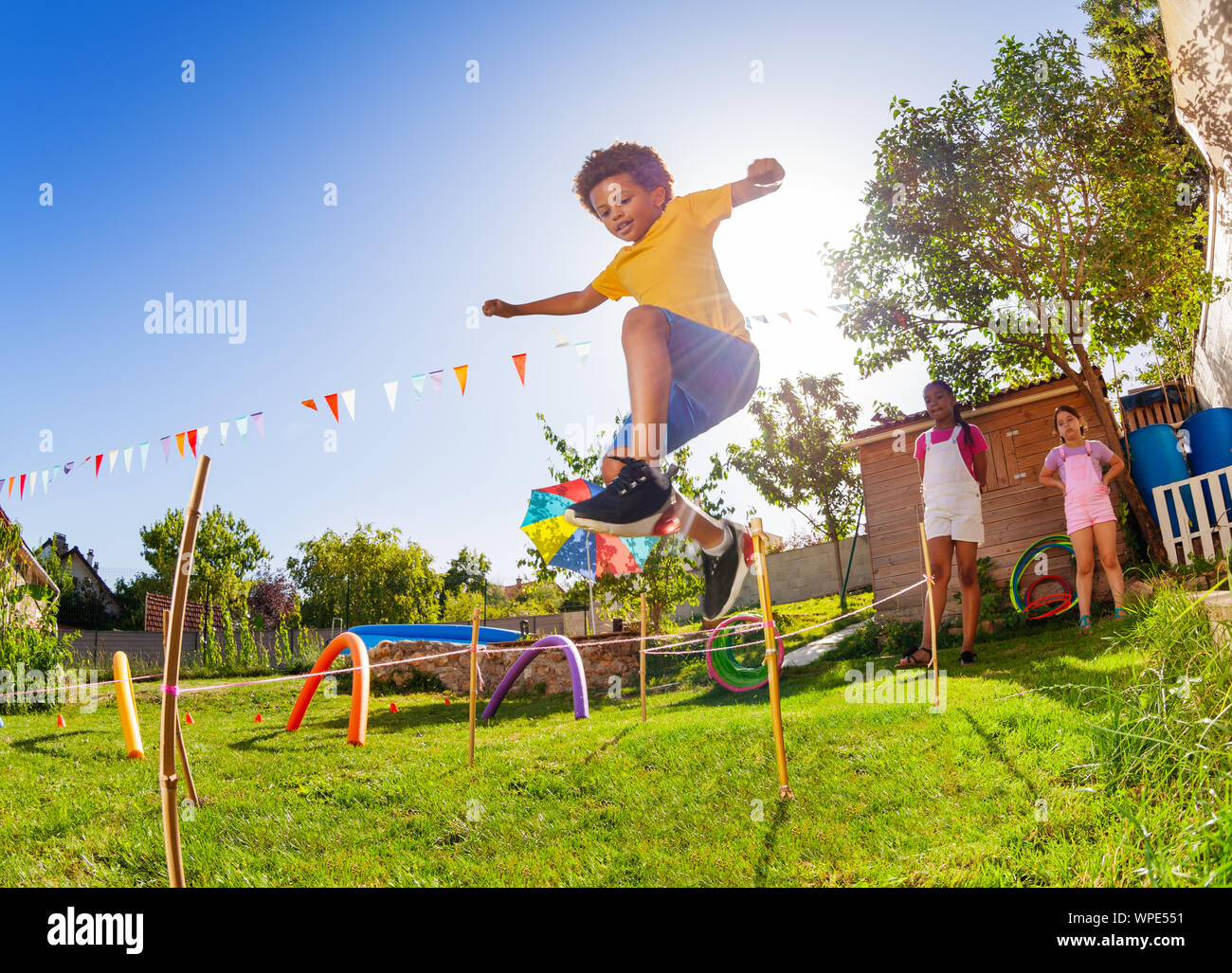 Boy jump over strings passing course of obstacles Stock Photo - Alamy