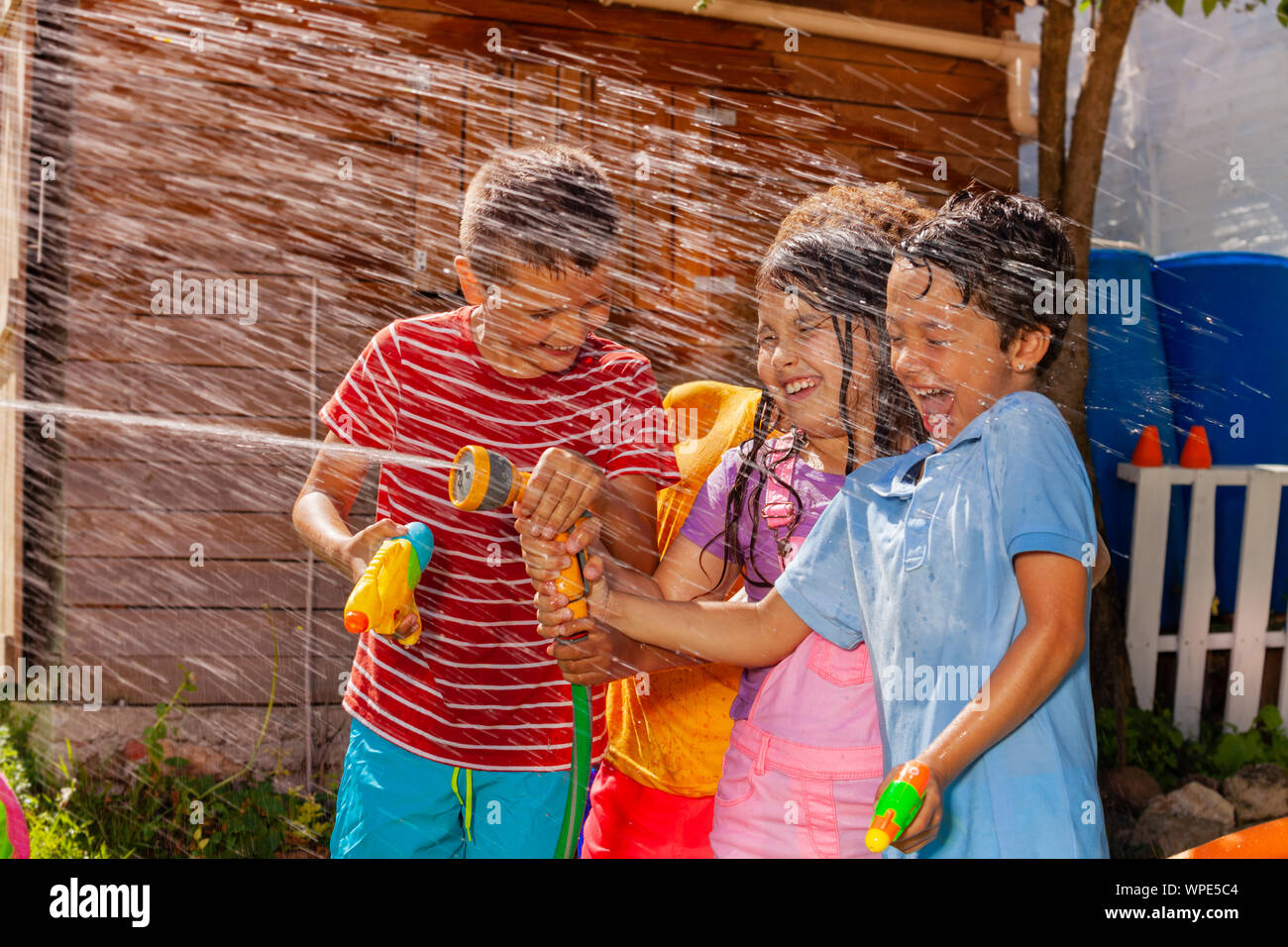 Kids play shooting water gun game, hot summer day Stock Photo Alamy