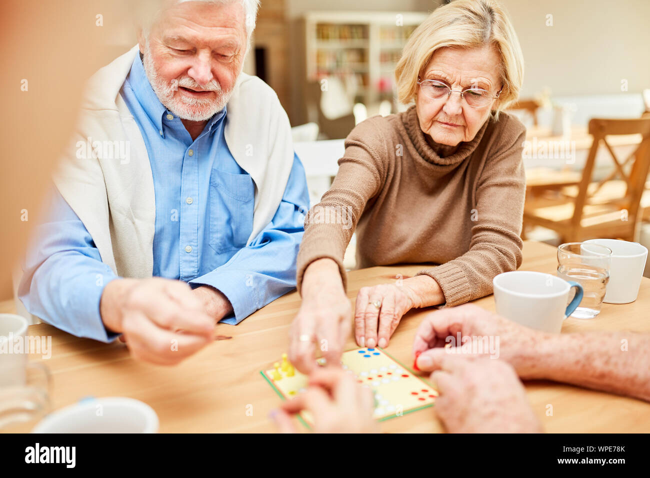 Seniors play together a board game in a nursing home or retirement home