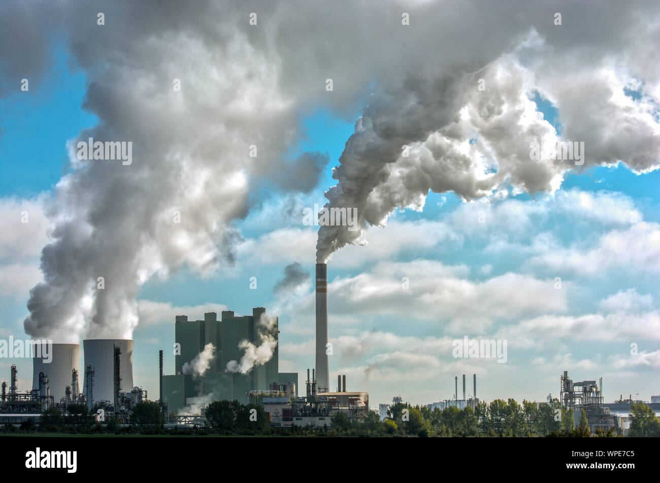 Panorama of a distant industrial plant with huge amounts of smoke Stock Photo