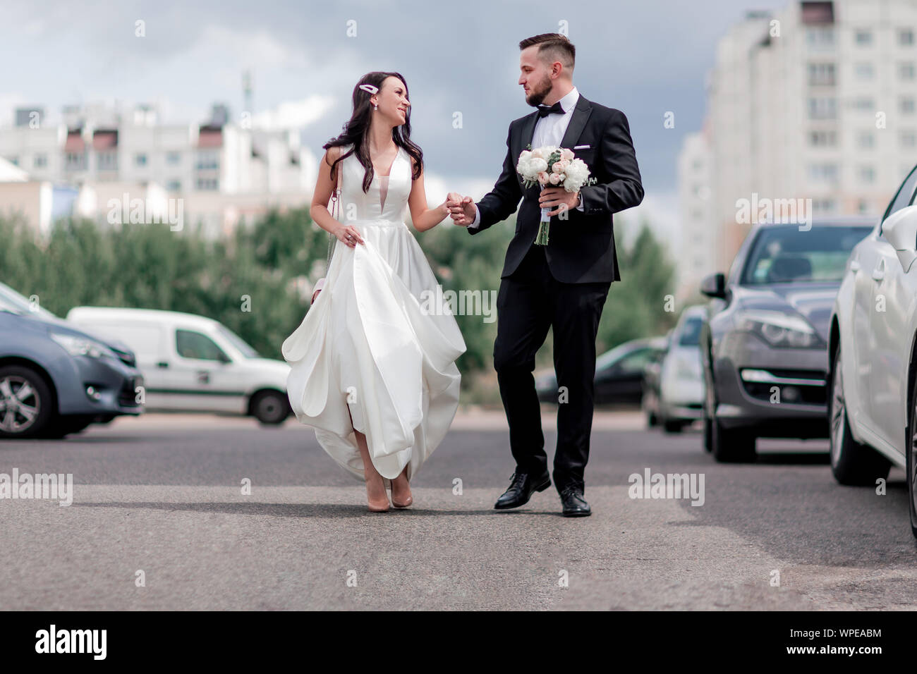 happy bride and groom walking down the street in the big city Stock ...