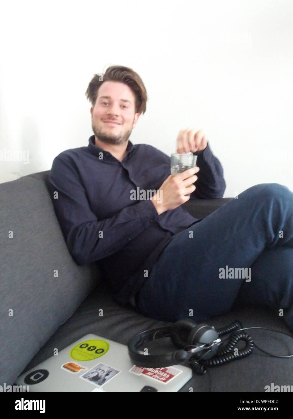 Man sitting couch smiling hi-res stock photography and images - Alamy