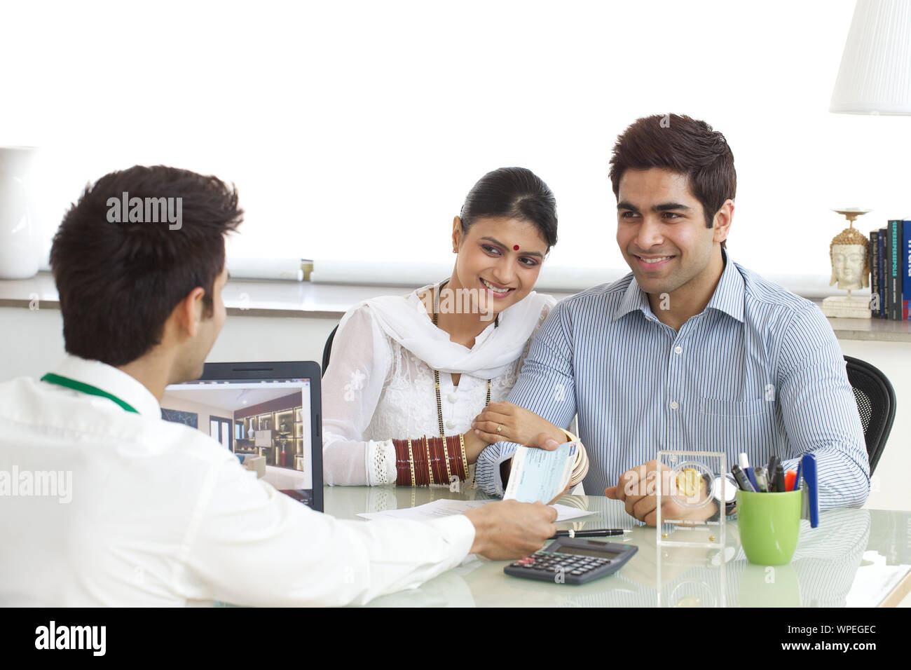 Bank manager giving loan cheque to young couple Stock Photo - Alamy