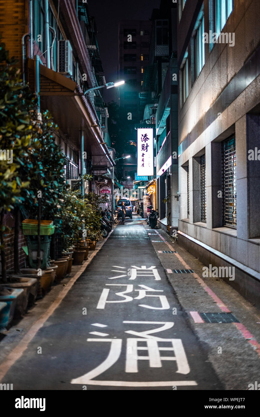 A Small Street In Urban Taipei City At Night Chinese Writing On The Road Man Standing At End Of Street Looking Up Towards A Neon Sign Stock Photo Alamy