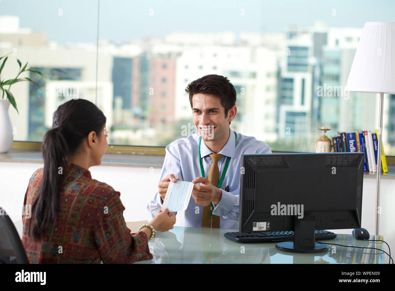 Bank manager giving loan cheque to a client Stock Photo - Alamy