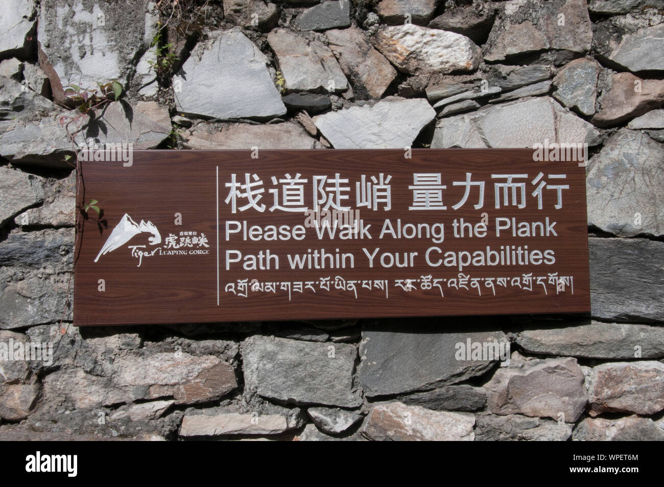 Bilingual safety warning at Tiger Leaping Gorge on the Jinsha River, a tributary of the upper Yangtze in Yunnan province, southwest China. Stock Photo