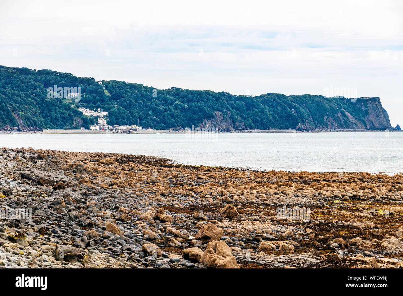 The rocky beach at Buck's Mills in Bideford Bay, the village of Clovelly in the distance, North Devon, UK Stock Photo