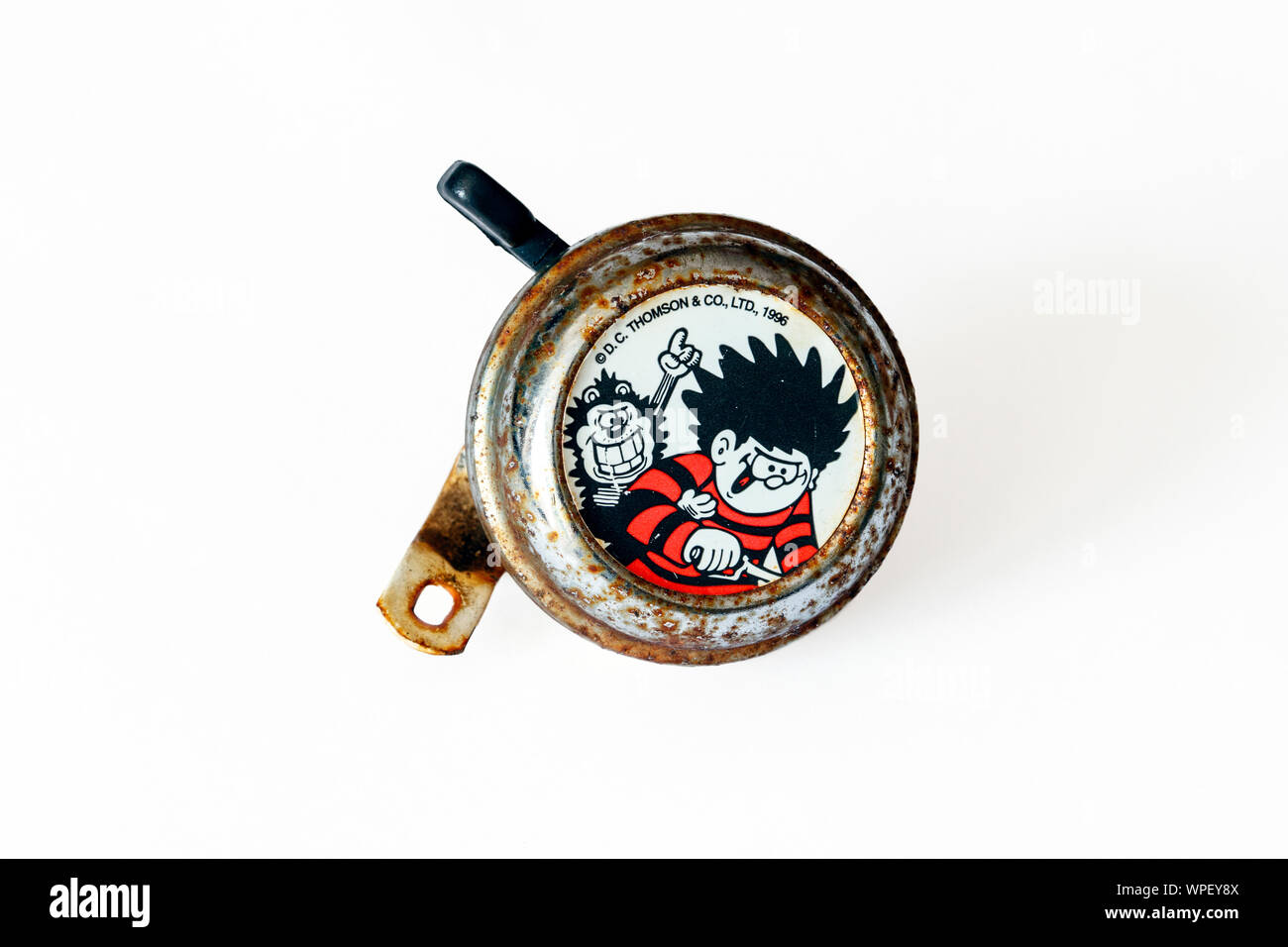 An old and rusty 'Dennis the Menace and Gnasher' (characters from the Beano children's comic) bicycle bell, isolated on a white background Stock Photo