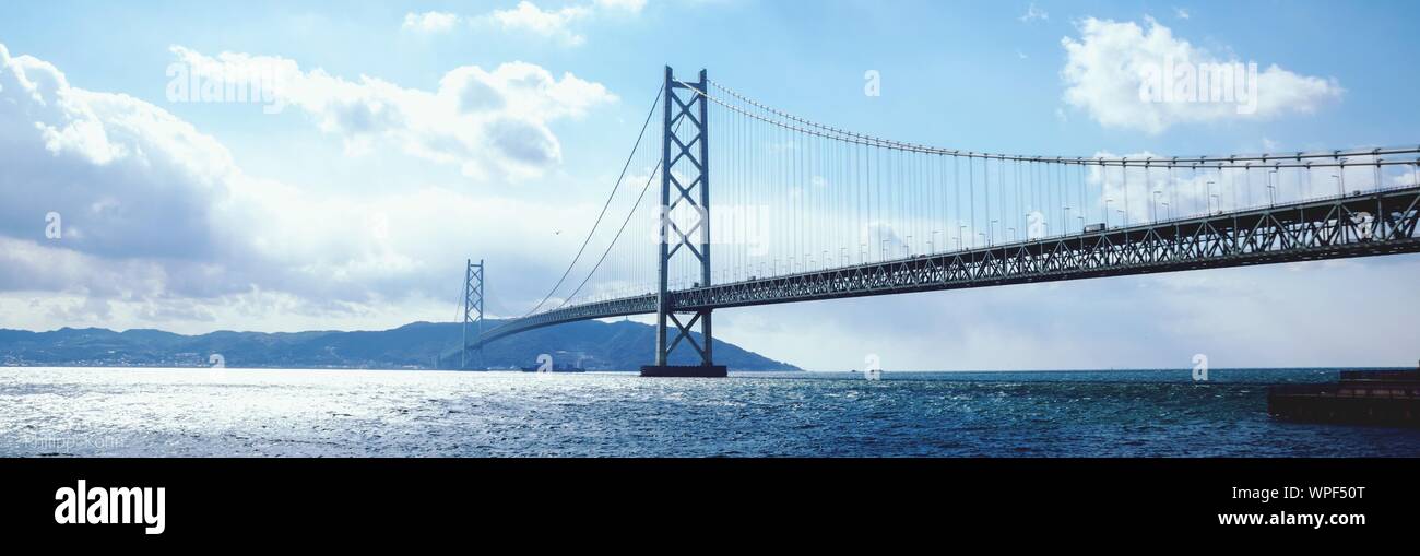 Akashi Kaikyo Bridge Over Sea Against Sky Stock Photo