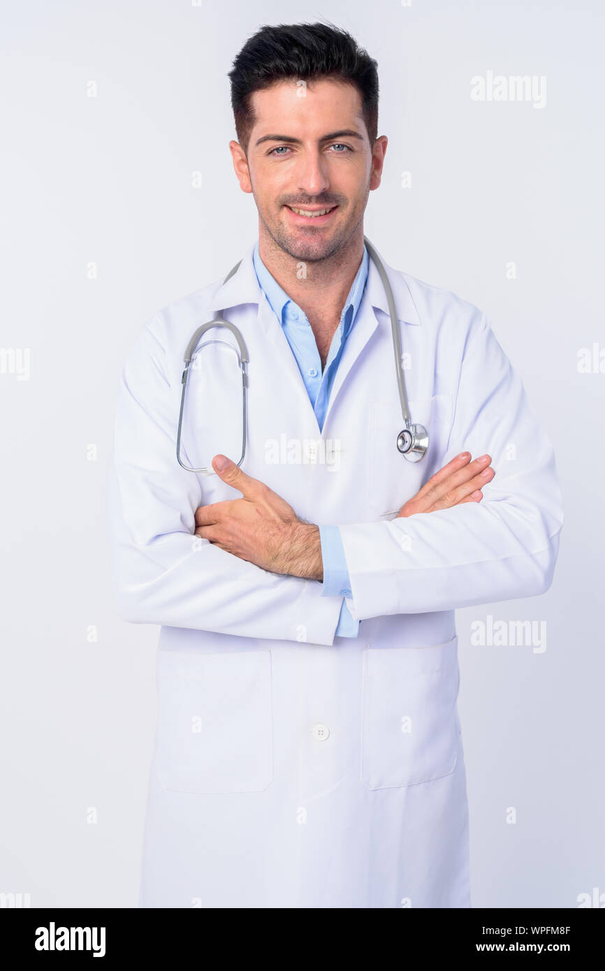Portrait of happy young handsome man doctor smiling with arms crossed ...