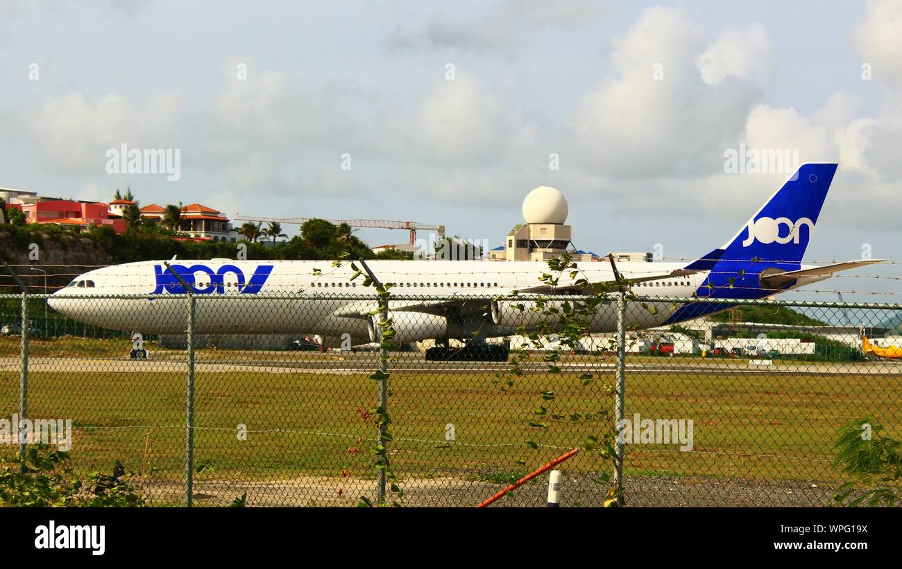 A Joon (defunct and now operated by Air France) Airbus A340-313 F-GLZP, taxiing on the runway prior to take off from SXM airport, St Maarten. Stock Photo