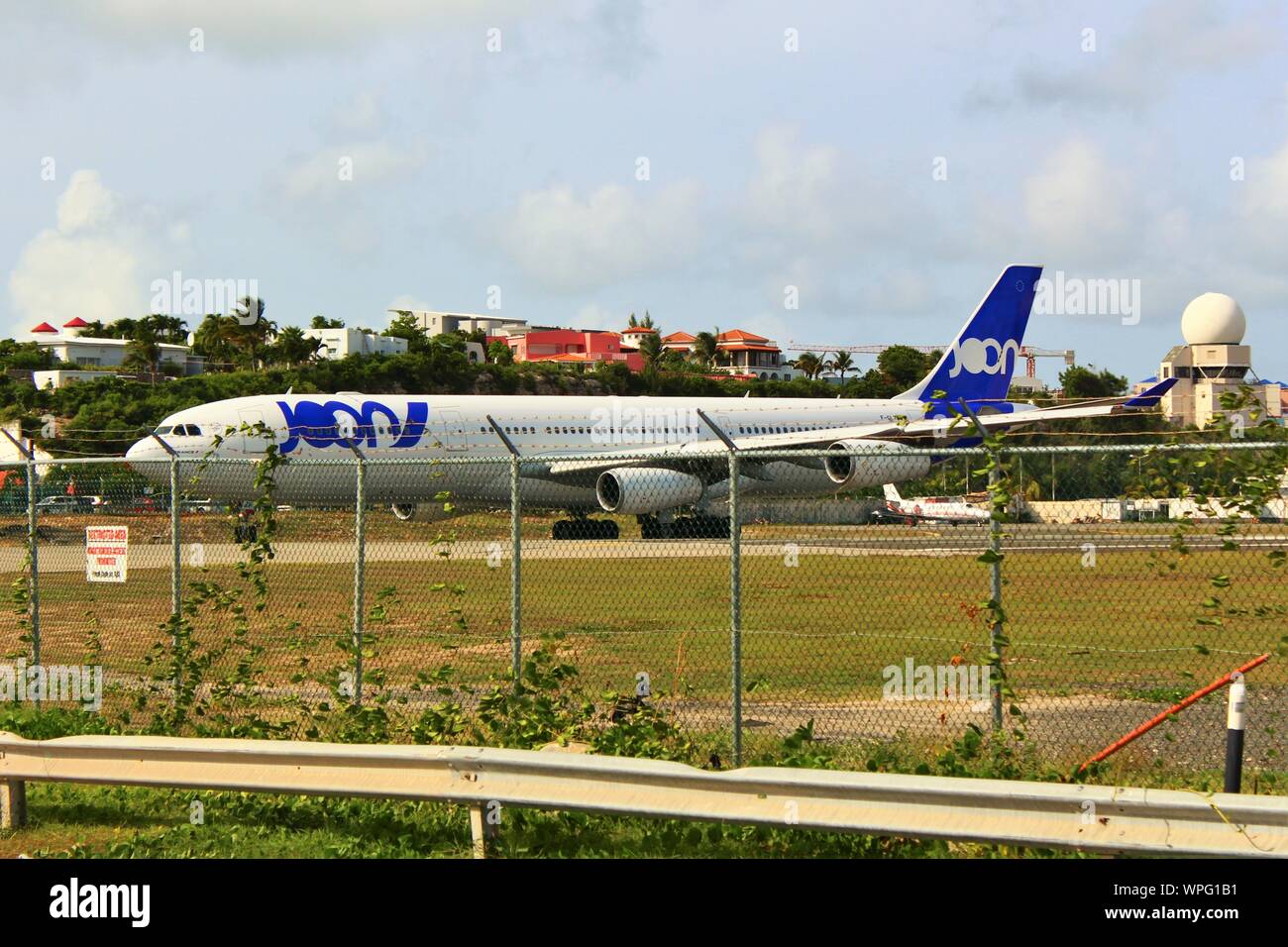 A Joon (defunct and now operated by Air France) Airbus A340-313 F-GLZP, taxiing on the runway prior to take off from SXM airport, St Maarten. Stock Photo
